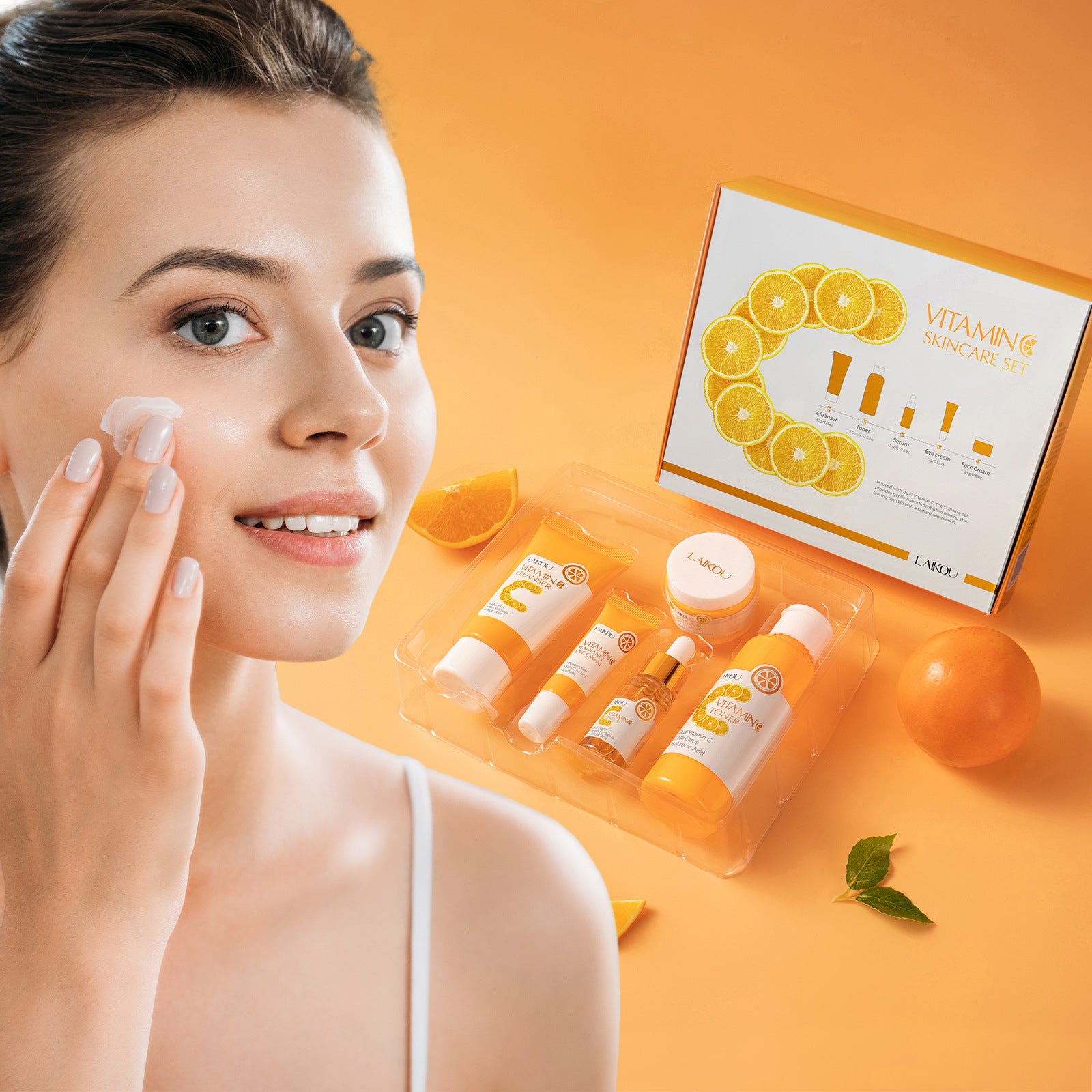 Woman applying vitamin C skincare cream with brightening benefits, displaying vitamin C skincare set with complete 5-piece routine on orange background